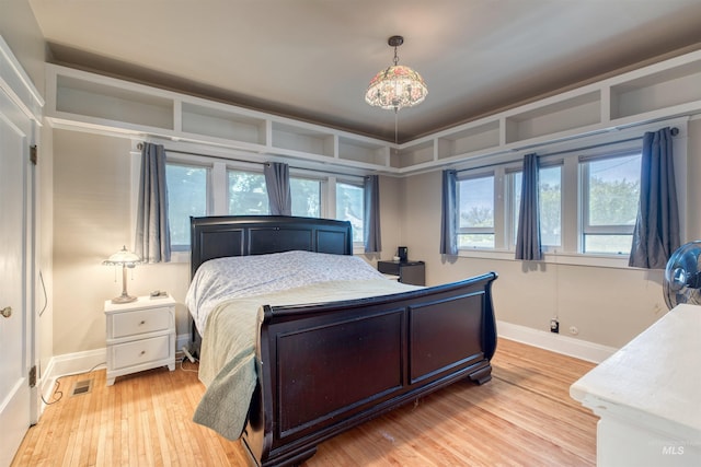 bedroom featuring visible vents, baseboards, and light wood-style floors