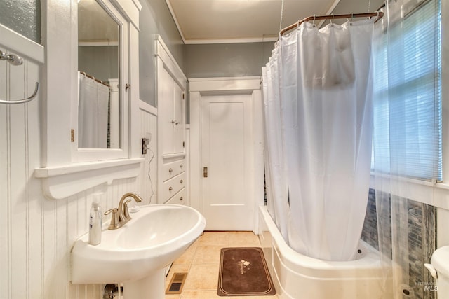 full bath with a sink, shower / tub combo with curtain, and tile patterned flooring