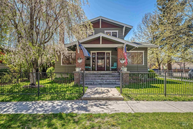 view of front of property featuring a fenced front yard, a porch, and a front lawn