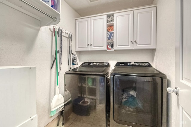 laundry area featuring washer and dryer, cabinet space, visible vents, and tile patterned flooring