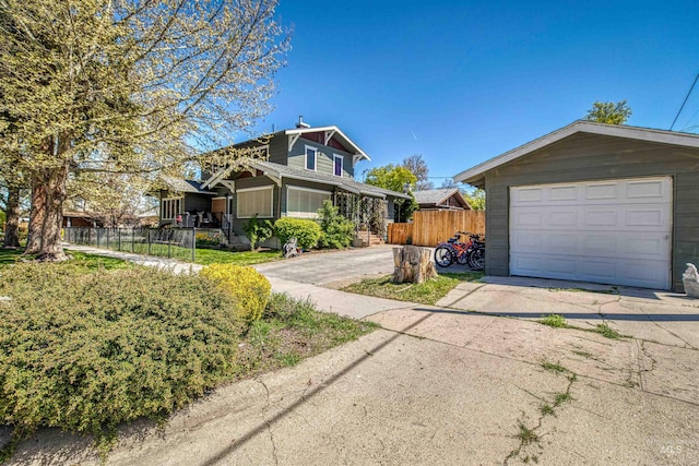 view of front of home featuring concrete driveway and fence