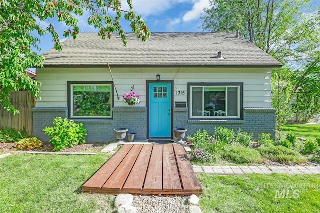 1315 E Lincoln Ave, Nampa, ID 83686 - bungalow-style home with brick siding, roof with shingles, and a front yard