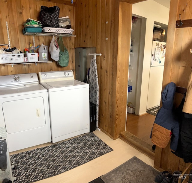 laundry room featuring washer and dryer and wood walls