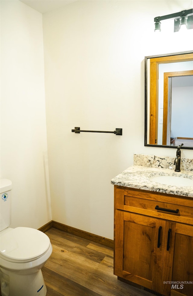 bathroom featuring hardwood / wood-style floors, vanity, and toilet