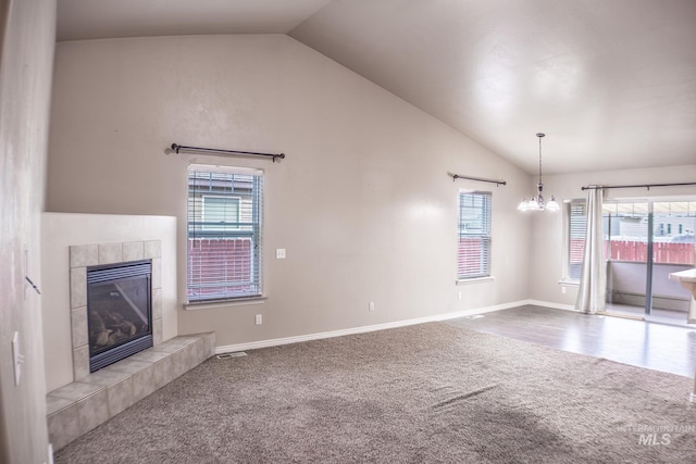 1155 Caswell Ave W, Twin Falls, ID 83301 - unfurnished living room featuring lofted ceiling, carpet floors, a chandelier, a tiled fireplace, and healthy amount of natural light
