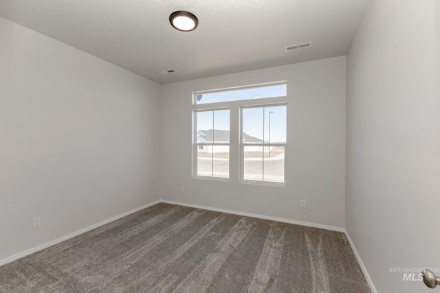 spare room with visible vents, baseboards, and carpet