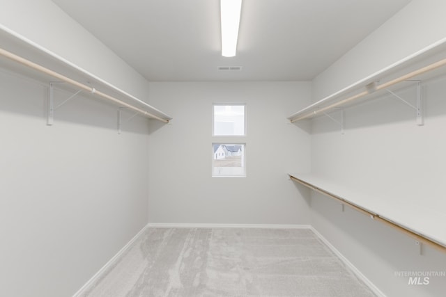 spacious closet featuring visible vents and light carpet