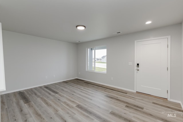 spare room featuring visible vents, baseboards, and light wood-style floors