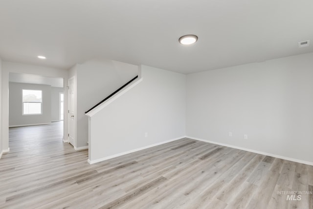 spare room featuring visible vents, baseboards, and light wood-style floors