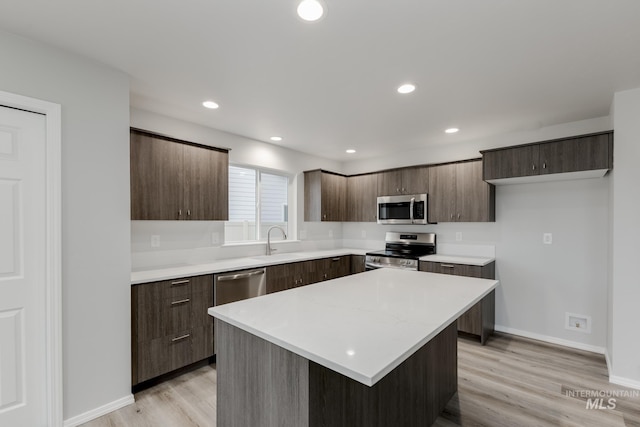 kitchen featuring stainless steel appliances, modern cabinets, light countertops, and a sink