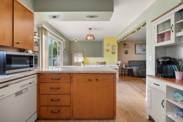 1713 12th St, Lewiston, ID 83501 - kitchen with white dishwasher, a peninsula, stainless steel microwave, light countertops, and light wood-style floors