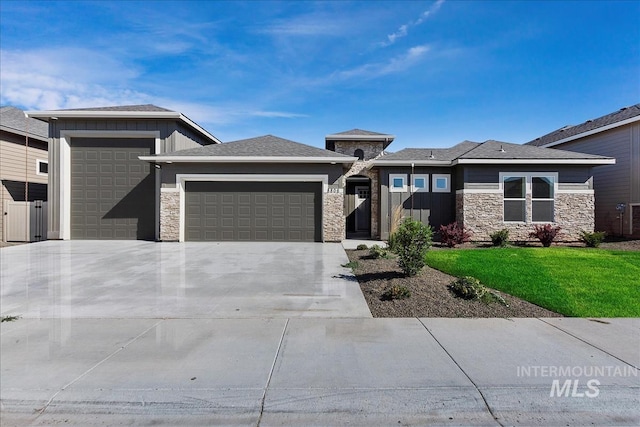 prairie-style home with a front yard and a garage