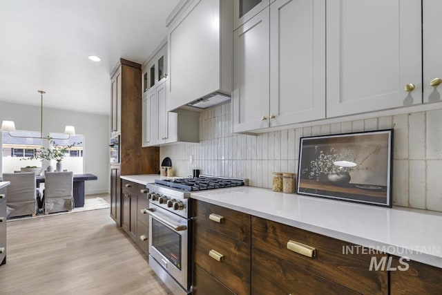 2215 Kooskia Loop, Twin Falls, ID 83301 - kitchen with high end stove, light countertops, tasteful backsplash, glass insert cabinets, and recessed lighting