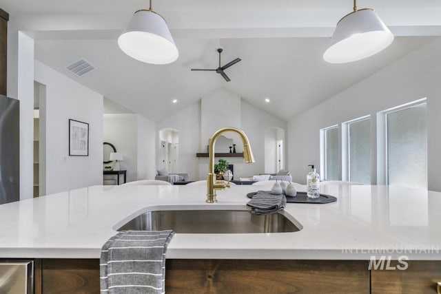 2215 Kooskia Loop, Twin Falls, ID 83301 - kitchen featuring open floor plan, arched walkways, light stone counters, pendant lighting, and vaulted ceiling