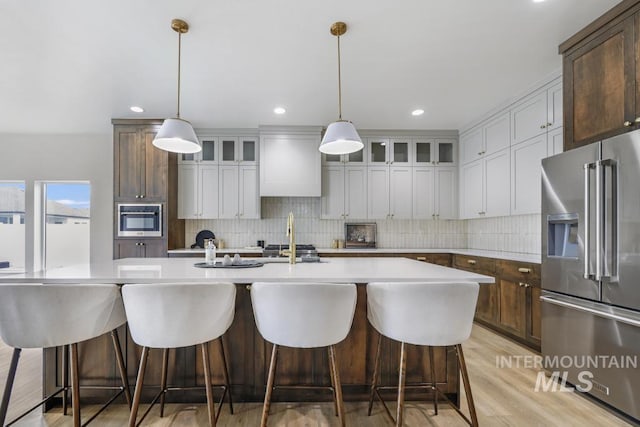 2215 Kooskia Loop, Twin Falls, ID 83301 - kitchen featuring high quality fridge, light countertops, tasteful backsplash, an island with sink, and recessed lighting