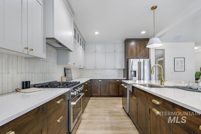2215 Kooskia Loop, Twin Falls, ID 83301 - kitchen featuring stainless steel appliances, dark brown cabinetry, white cabinetry, pendant lighting, and tasteful backsplash