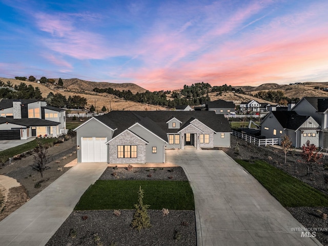 view of front of property featuring a mountain view, a yard, and a garage