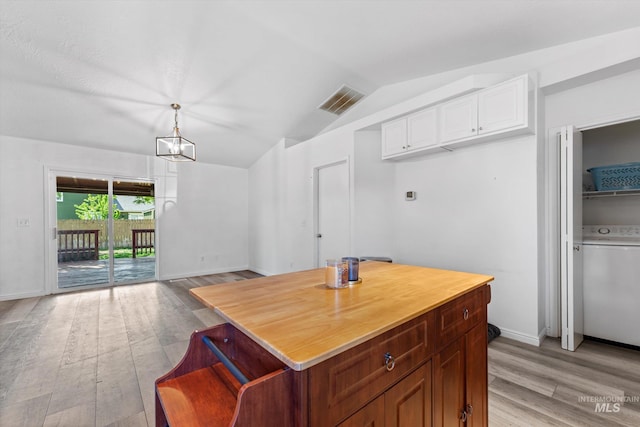 3004 Sandstone Pl, Caldwell, ID 83605 - kitchen featuring washer / clothes dryer, light wood-style flooring, white cabinetry, vaulted ceiling, and pendant lighting
