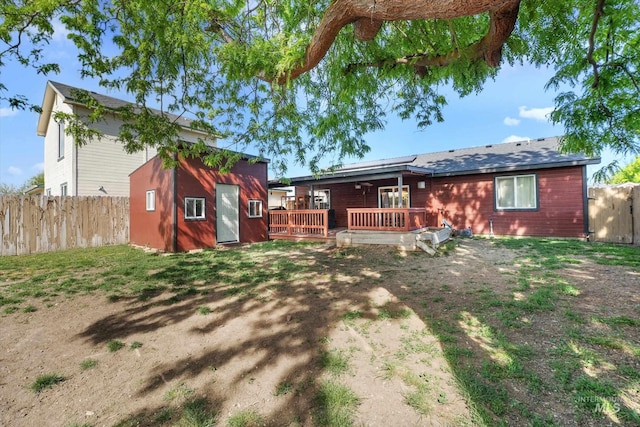 3004 Sandstone Pl, Caldwell, ID 83605 - back of house with an outbuilding, a deck, a fenced backyard, and roof mounted solar panels