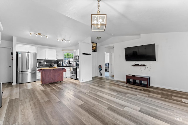 3004 Sandstone Pl, Caldwell, ID 83605 - living room featuring a chandelier, vaulted ceiling, and light wood-type flooring