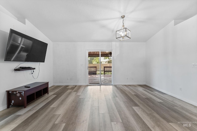 3004 Sandstone Pl, Caldwell, ID 83605 - unfurnished living room with wood finished floors, a chandelier, and baseboards