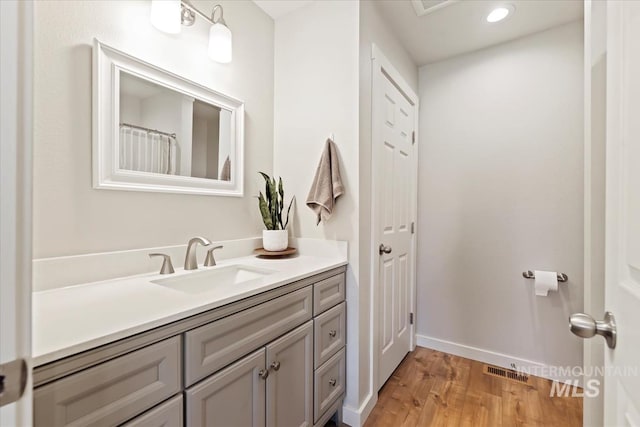 bathroom featuring recessed lighting, wood finished floors, visible vents, vanity, and baseboards