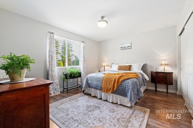 bedroom featuring a closet, wood finished floors, and baseboards