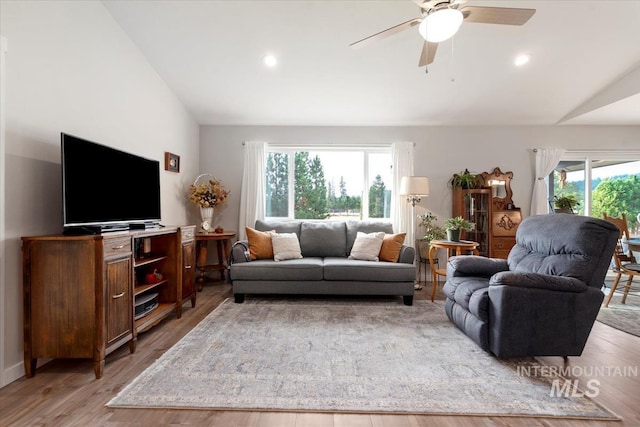 living room featuring a healthy amount of sunlight, vaulted ceiling, and light wood finished floors