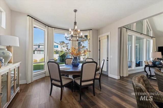 dining room with a wealth of natural light, dark hardwood / wood-style flooring, and an inviting chandelier