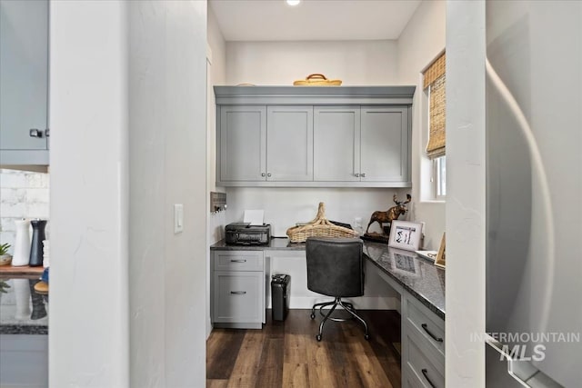 office space with dark hardwood / wood-style flooring and built in desk