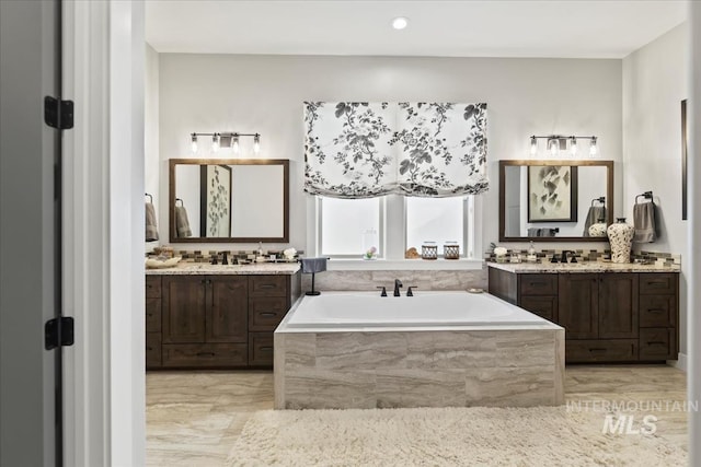 bathroom with tiled bath and vanity