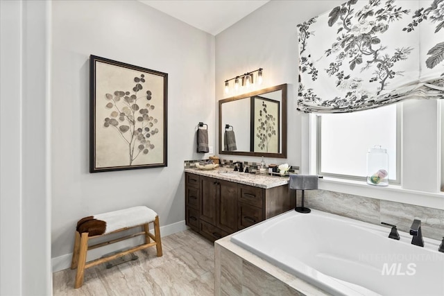 bathroom with tiled bath and vanity