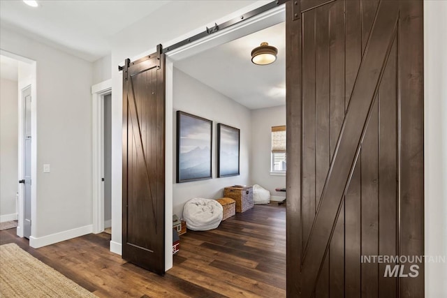 corridor featuring dark hardwood / wood-style flooring and a barn door