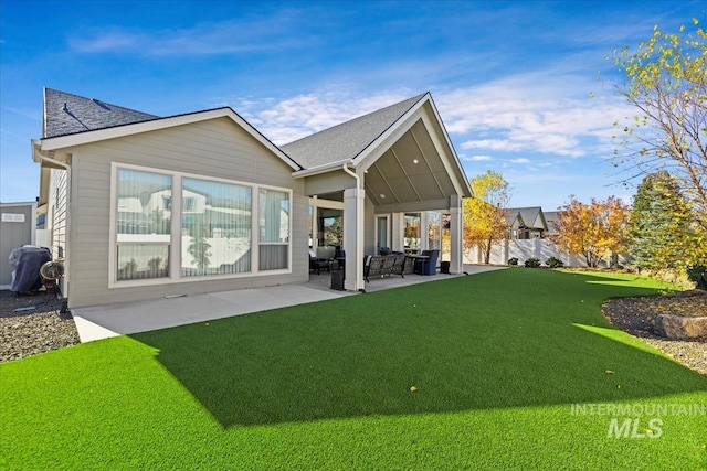 back of property featuring a lawn and a patio