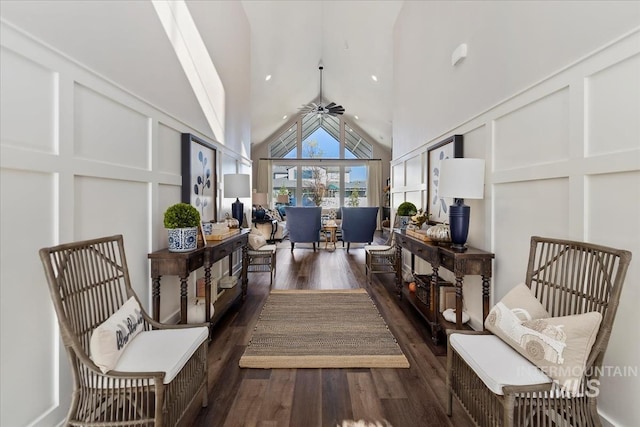 living area with high vaulted ceiling, dark hardwood / wood-style floors, and ceiling fan