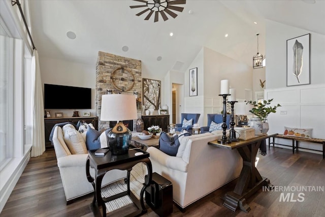 living room featuring ceiling fan, vaulted ceiling, and dark wood-type flooring