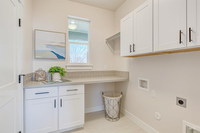 washroom with cabinet space, baseboards, hookup for a gas dryer, hookup for a washing machine, and electric dryer hookup