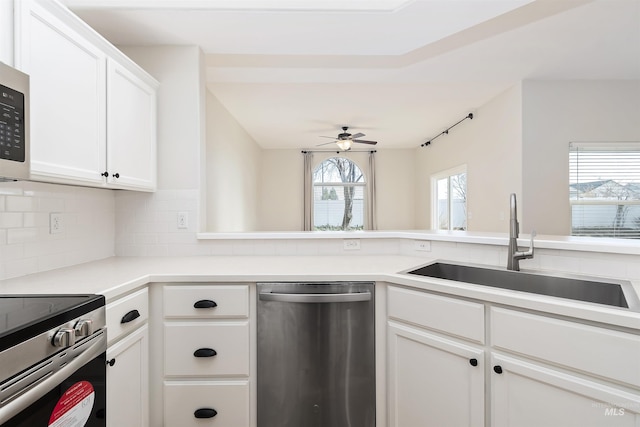 kitchen with ceiling fan, tasteful backsplash, sink, white cabinetry, and appliances with stainless steel finishes