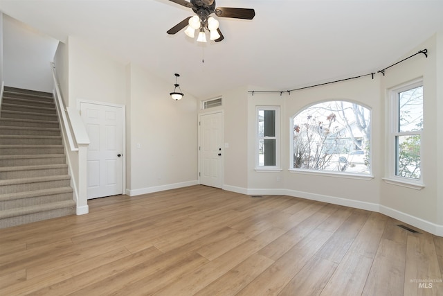 unfurnished living room featuring light wood-type flooring, ceiling fan, and a healthy amount of sunlight