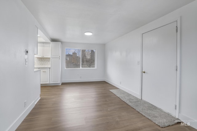 201 E 27th St, Burley, ID 83318 - unfurnished living room featuring wood finished floors and baseboards