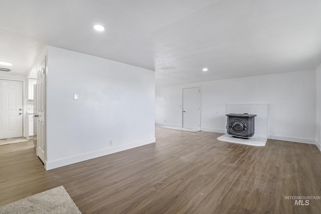 201 E 27th St, Burley, ID 83318 - unfurnished living room with a wood stove, wood finished floors, and baseboards