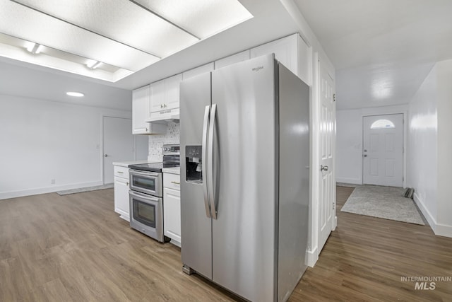201 E 27th St, Burley, ID 83318 - kitchen with tasteful backsplash, white cabinets, light wood-type flooring, under cabinet range hood, and stainless steel appliances