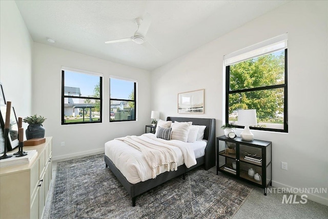 bedroom with ceiling fan, a textured ceiling, and multiple windows