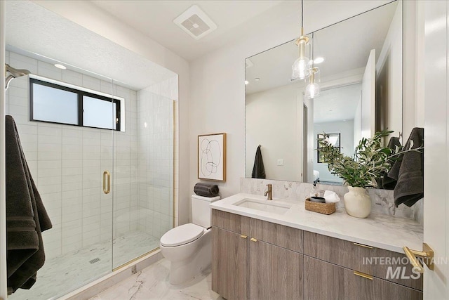 bathroom featuring a shower with door, vanity, and toilet