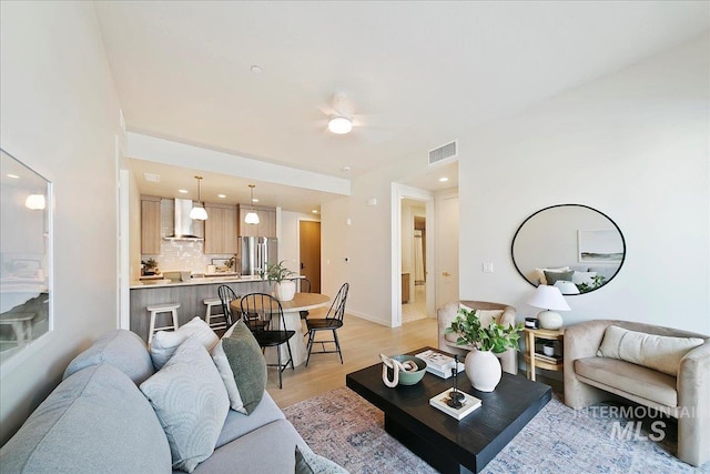 living room with light hardwood / wood-style floors and ceiling fan