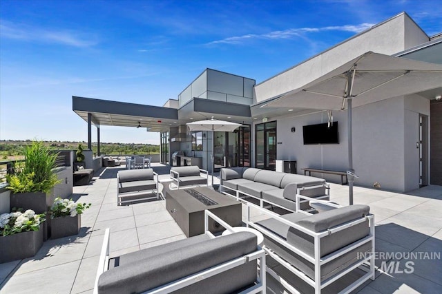 view of patio with an outdoor living space with a fire pit