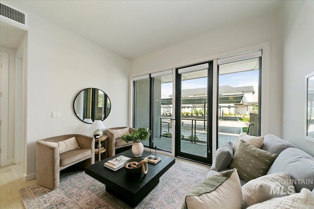 living room with a wealth of natural light and light hardwood / wood-style floors