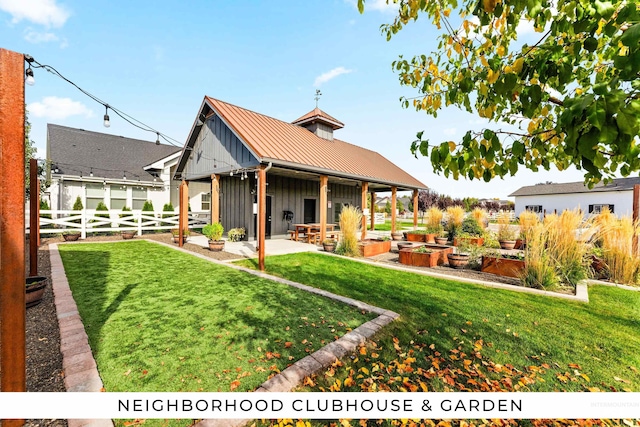 back of property with fence, board and batten siding, a vegetable garden, a patio area, and a yard