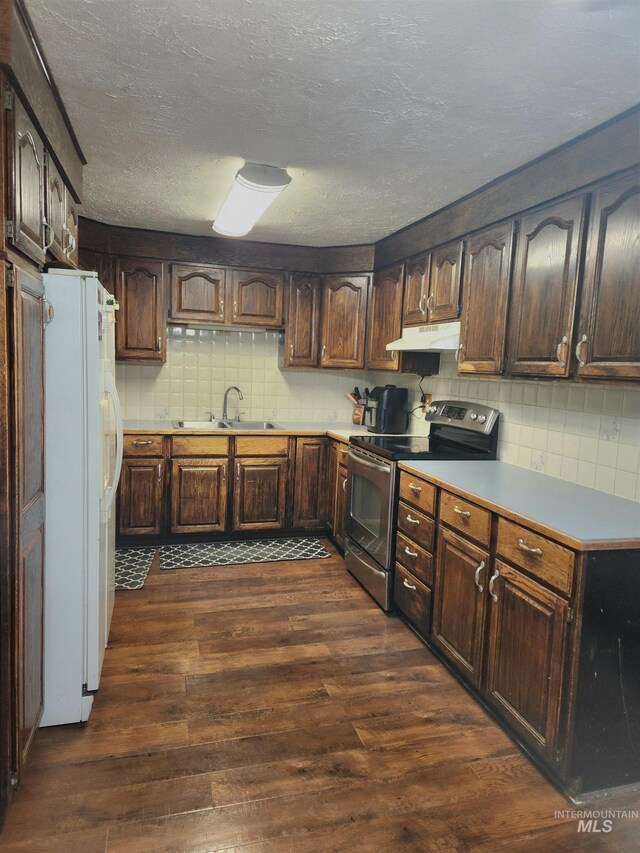 846 Wyoming St, Gooding, ID 83330 - kitchen with under cabinet range hood, dark wood finished floors, a sink, stainless steel range with electric cooktop, and freestanding refrigerator