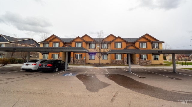 multi unit property with stone siding and covered and uncovered parking